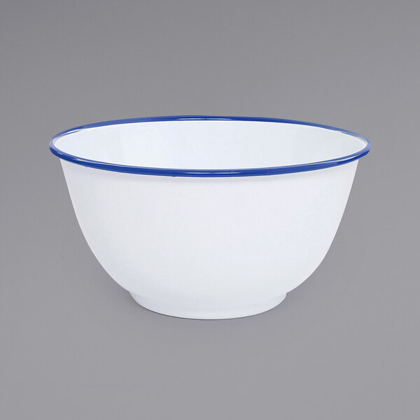 A white Crow Canyon Home enamelware bowl with blue rim.