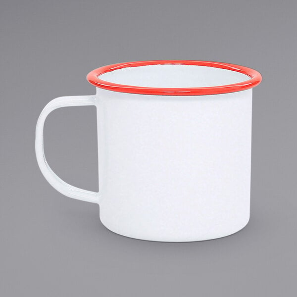 A white enamel mug with a red rim.