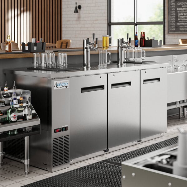 An Avantco stainless steel beer dispenser with three taps on a counter.