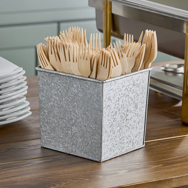 An American Metalcraft galvanized metal rectangular utensil holder with wooden utensils inside.