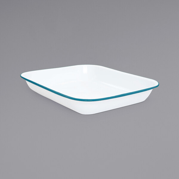 A white enamelware roasting pan with a turquoise rim.