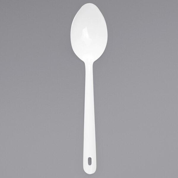 A white enamelware serving spoon with a silver handle.