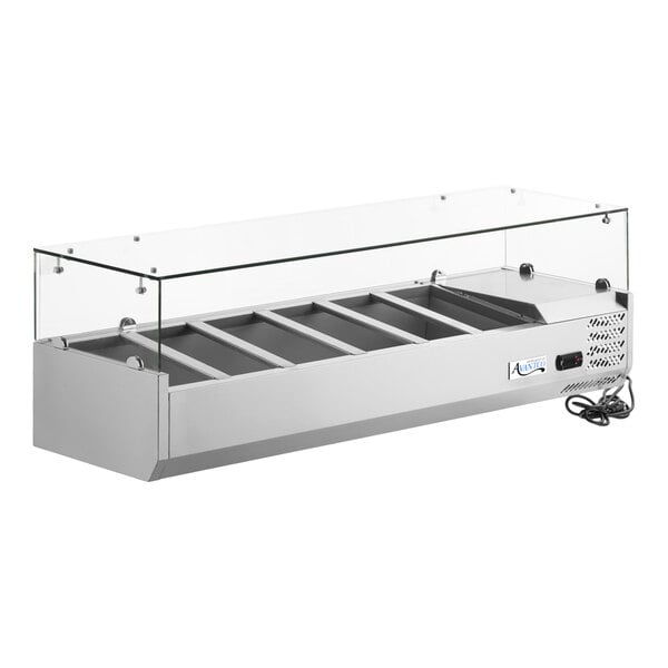 A stainless steel countertop refrigerated prep rail with a glass sneeze guard and multiple compartments.