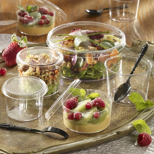 A clear plastic container with a clear plastic lid holding a salad.