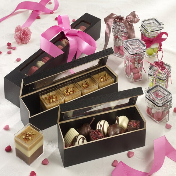 Solia wooden macaron case with a pink ribbon on a table.