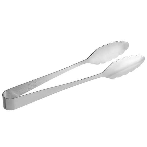 A pair of Carlisle stainless steel scalloped serving tongs with white handles.