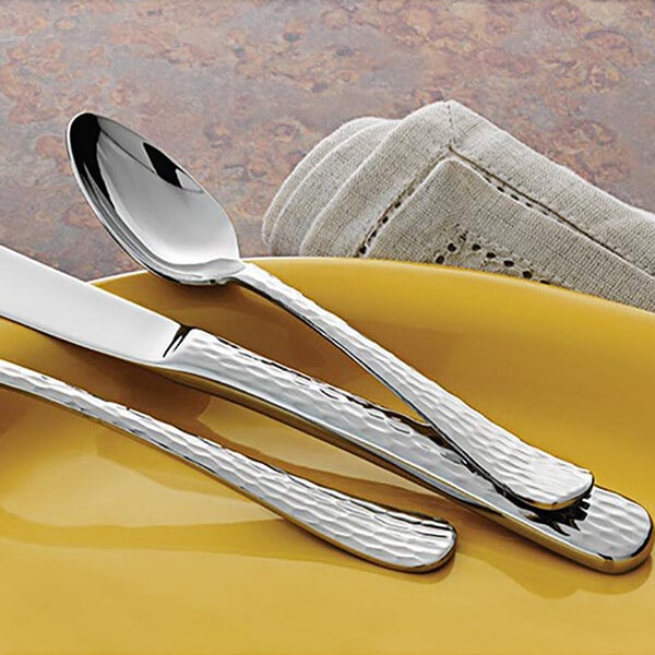 A Libbey stainless steel teaspoon and knife on a plate.