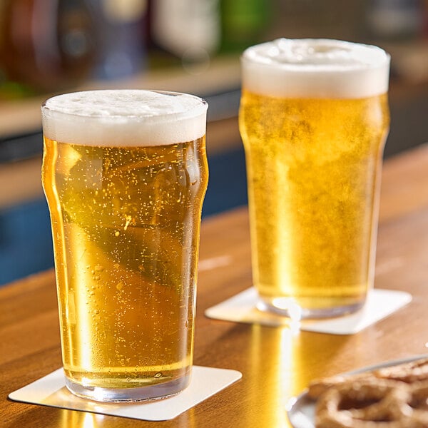 Two Anchor Hocking English Pub glasses of beer on a wooden table.