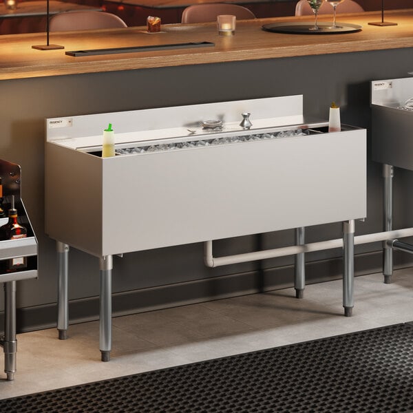 A stainless steel underbar ice bin with bottle holders and a sliding lid, designed for commercial bar use.