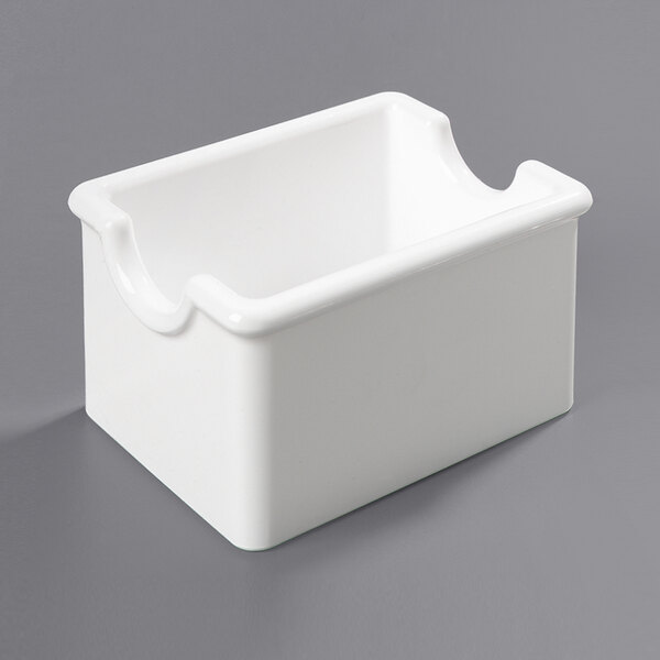 A white rectangular Carlisle plastic sugar caddy with a curved edge.