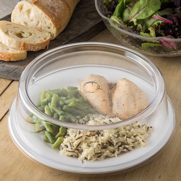 A Carlisle clear polycarbonate plate cover over a bowl of rice and meat on a table.