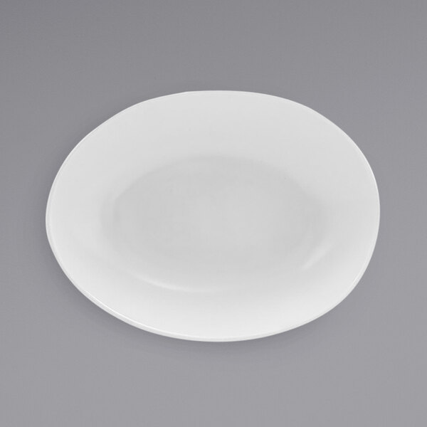A semi-matte white oval porcelain bowl with a round center on a gray surface.