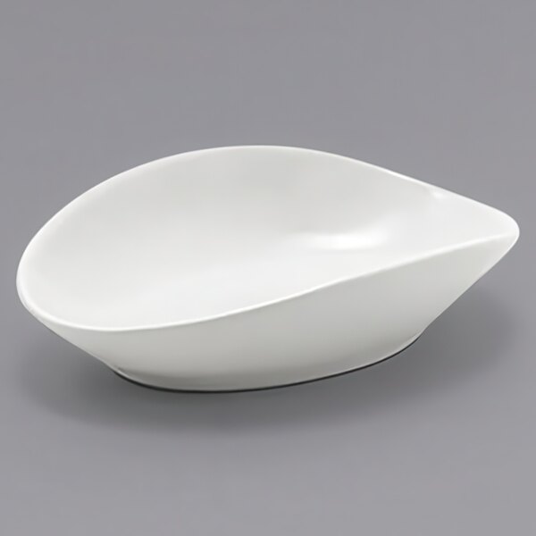 A white oval porcelain ramekin on a gray surface.