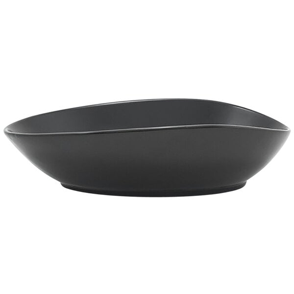 A close up of a Front of the House Tides semi-matte mussel oval porcelain bowl with a black finish.