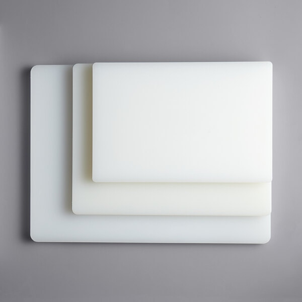 A stack of three white rectangular Thunder Group cutting boards.