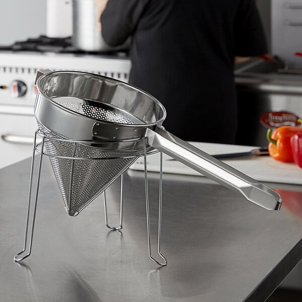 A stainless steel Choice fine china cap strainer on a counter.