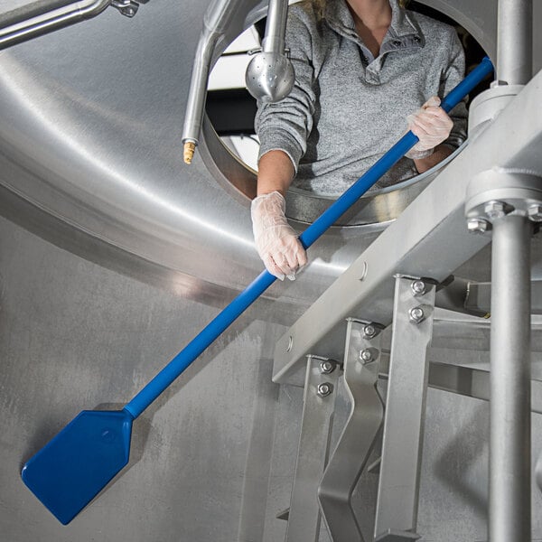 A woman holding a blue Carlisle paddle with nylon blade and polypropylene handle.