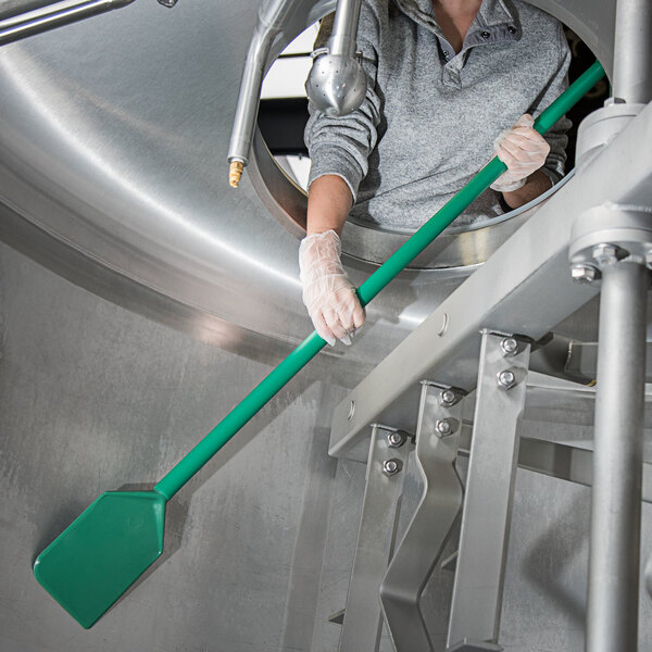 A woman holding a Carlisle green paddle with a yellow and green blade