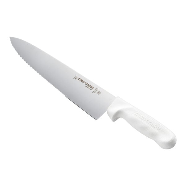 A large kitchen knife with a scalloped blade and a white ergonomic handle.