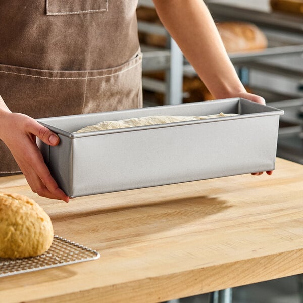 A rectangular glazed aluminized steel Pullman bread loaf pan measuring 16 by 4 by 4 inches, shown with dough inside.