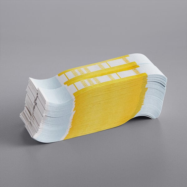 A stack of yellow and white self-adhesive currency straps.