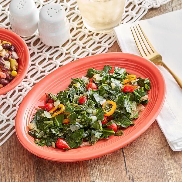 An Acopa Coral Reef oval stoneware platter with salad and a fork on it on a table with a bowl of corn and beans.