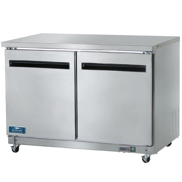 A stainless steel Arctic Air undercounter refrigerator with two doors.