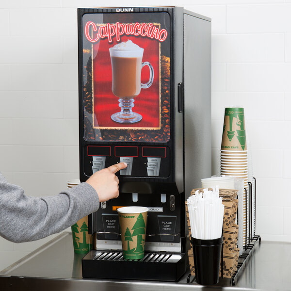 A person using a Bunn hot beverage dispenser to fill a cup.