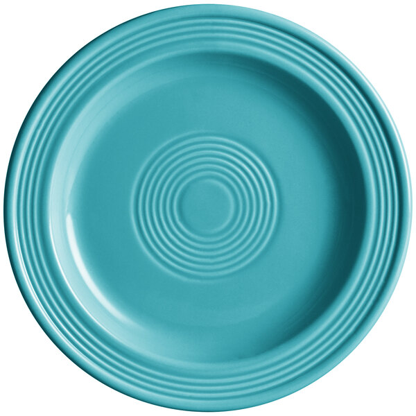 A close-up of an Acopa Capri Caribbean turquoise stoneware plate with a spiral pattern.