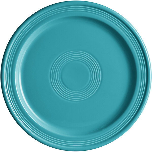A Caribbean turquoise stoneware plate with a circular pattern.