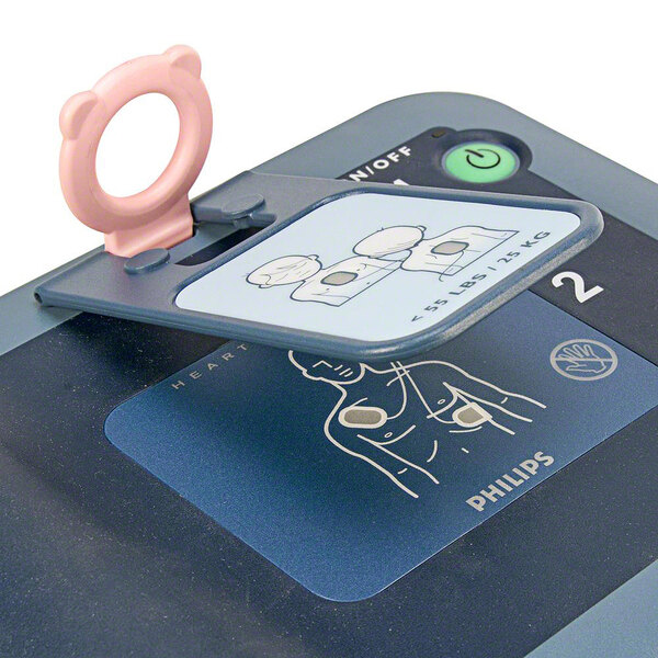 A close-up of a Philips Infant / Child Key for a HeartStart FRx AED with a pink ring attached.