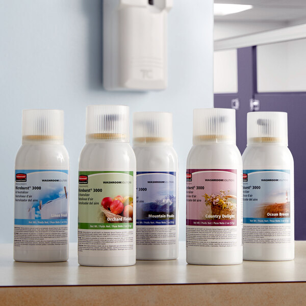 A row of white Rubbermaid Microburst air freshener refills on a counter.