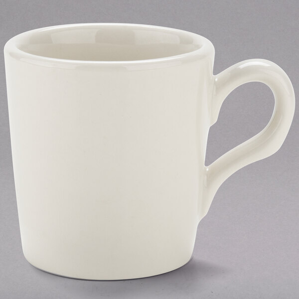 A white Tuxton espresso cup with a handle.