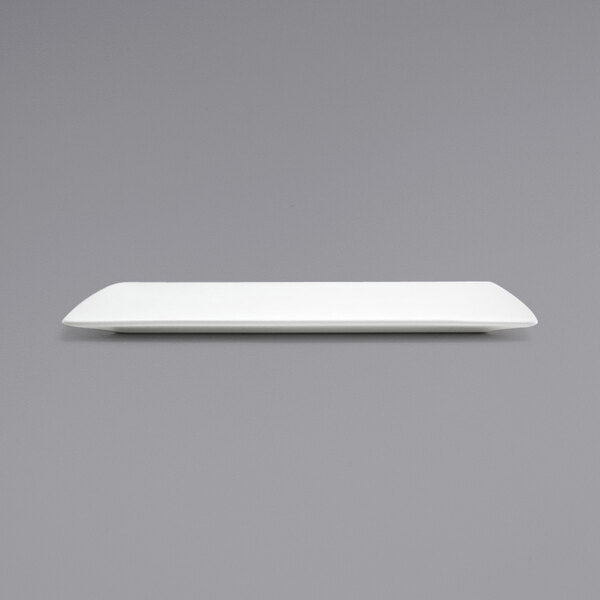 A white rectangular Front of the House porcelain plate on a gray surface.
