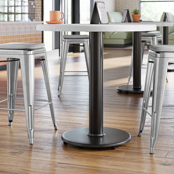 A Lancaster Table & Seating cast iron counter height table base with stools.