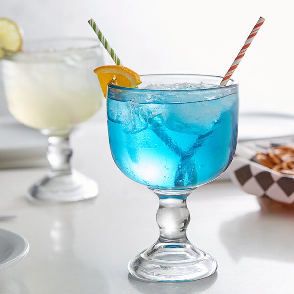 a glass with blue liquid and ice