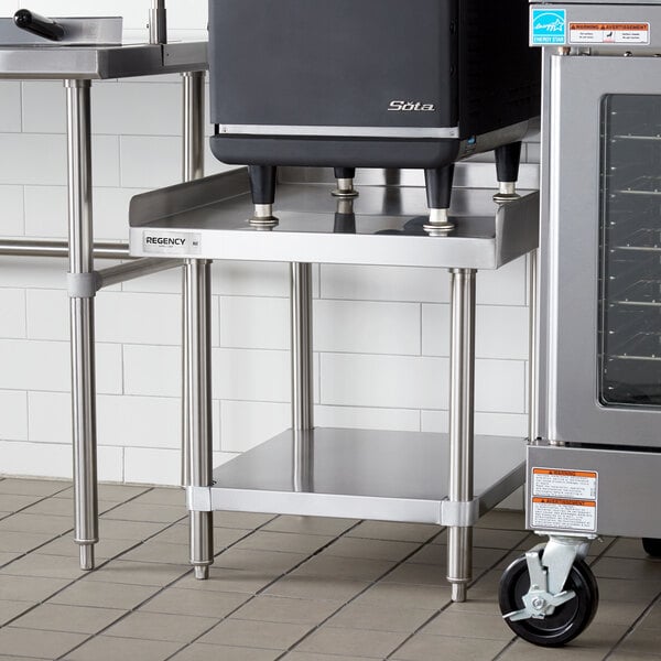 A Regency stainless steel equipment stand with stainless steel undershelf holding a stove and oven.