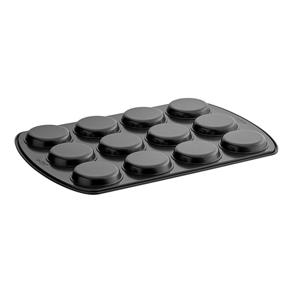 A black Wilton muffin top pan with six round circles.