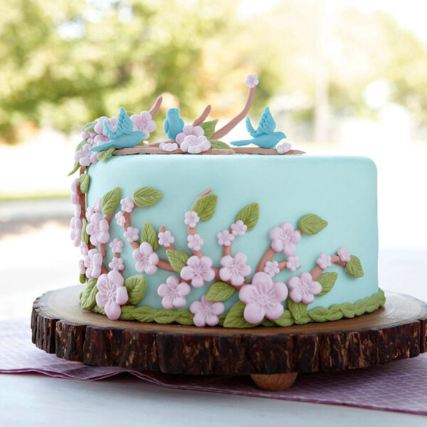 a cake with flowers and birds on top