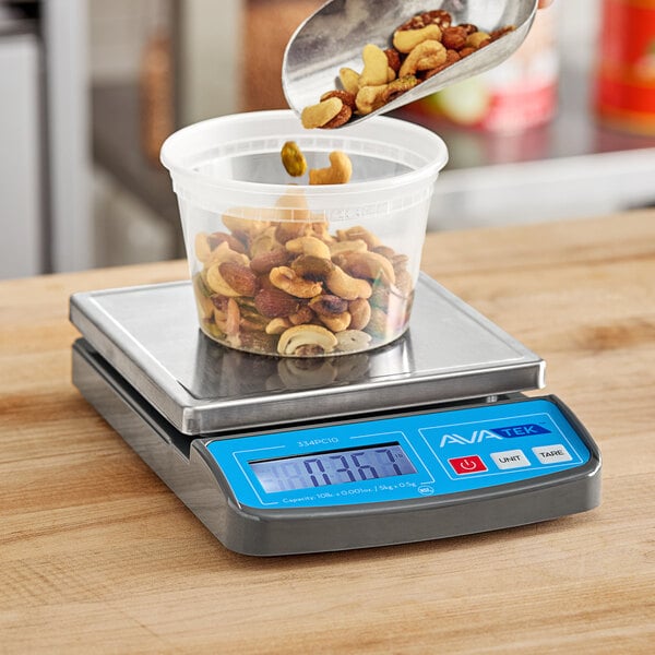 A person pouring nuts from a bowl into a container on an AvaWeigh compact digital portion scale.
