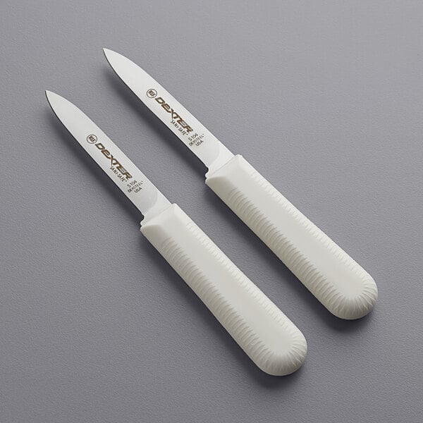 Two white Dexter-Russell Sani-Safe paring knives with smooth blades.