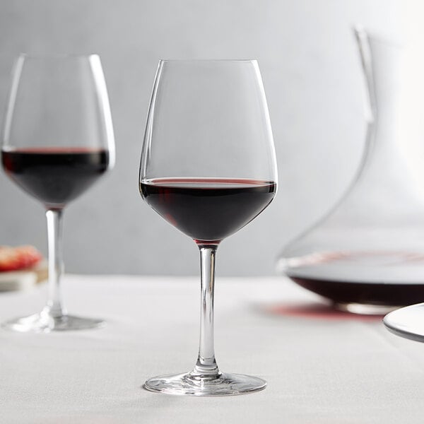 A couple of Arcoroc wine glasses on a table.