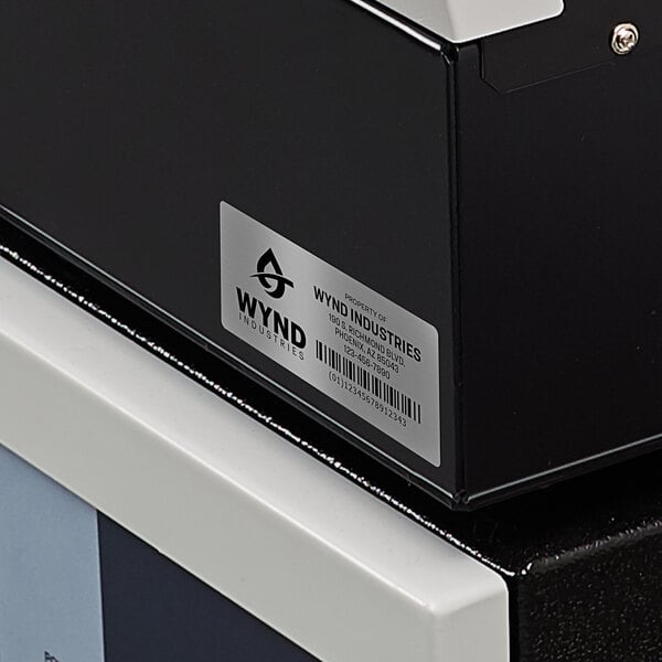 A black printer with a white Avery label on it.