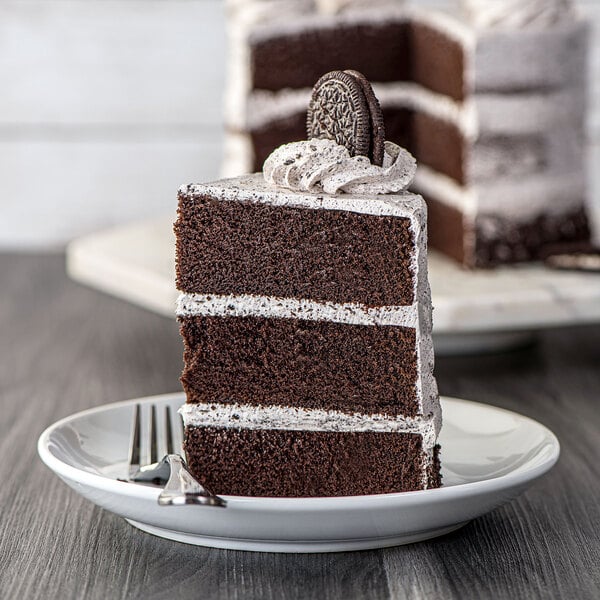 A slice of chocolate cake with Rich's Bettercreme Cookies 'N Creme Oreo whipped icing and cookies on top.