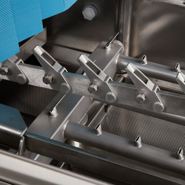 A close-up view of the stainless steel interior components of a commercial conveyor dishwasher.