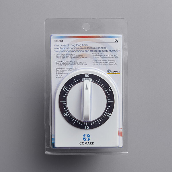 A Comark mechanical kitchen timer with a black and white dial in a plastic package.