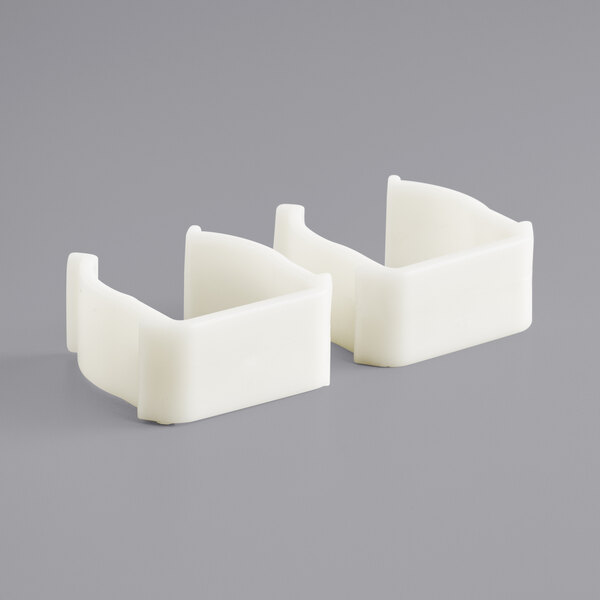 A pair of white plastic clamps.