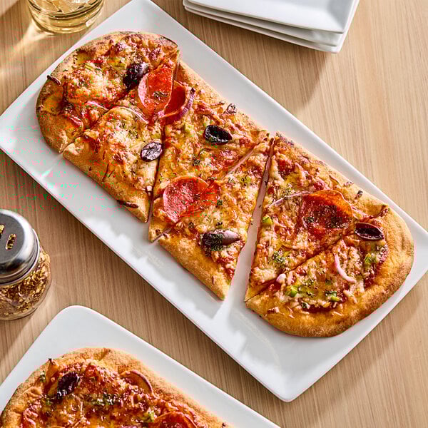 A plate with a slice of pizza on Rich's oval flatbread crust.