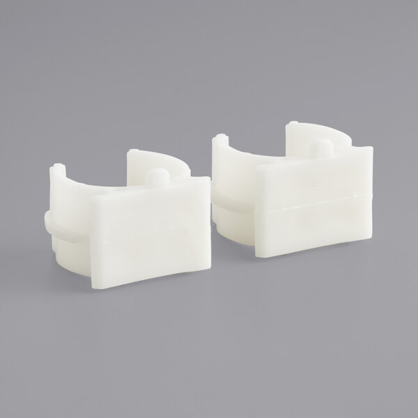 A pair of white plastic clamps.