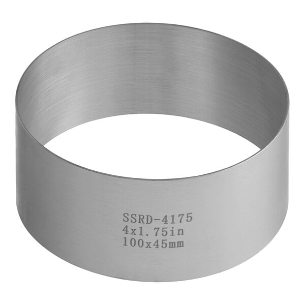 A stainless steel circular ring mold with writing on the side.
